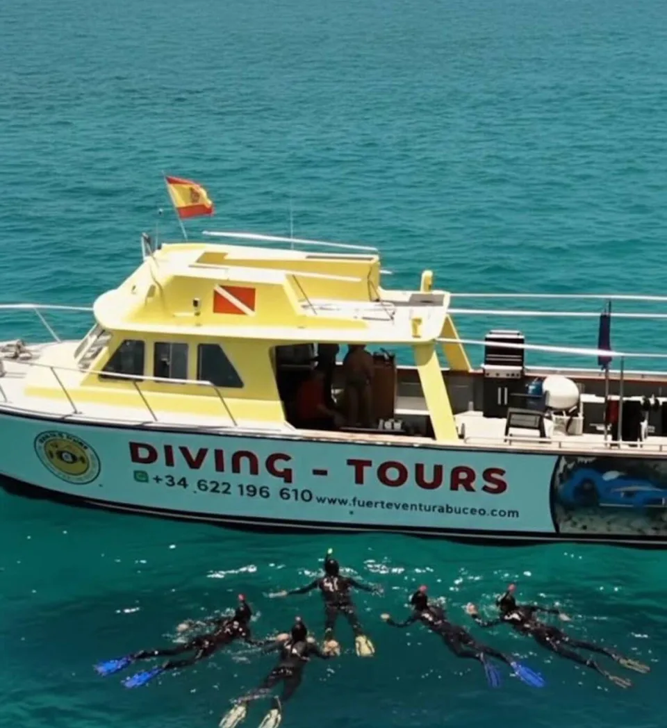 Barco de Fuerteventura Buceo junto a participantes haciendo snorkel en agua turquesa