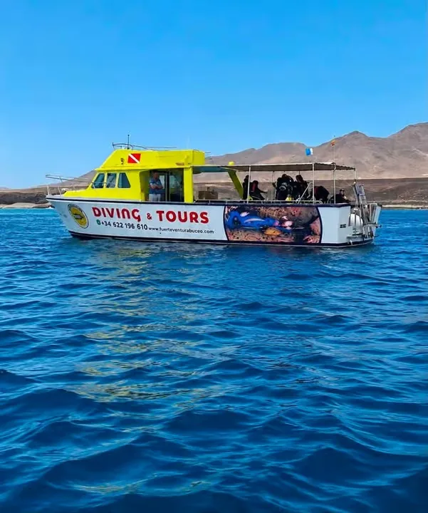 Barco amarillo de Fuerteventura Buceo navegando frente a la costa de Jandía