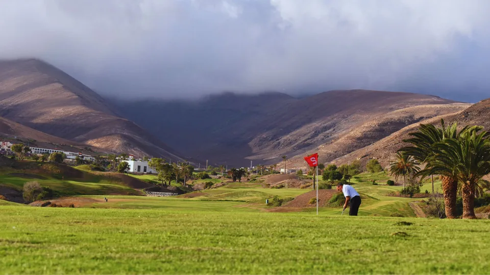 Green and distant player with the Jandía mountains behind