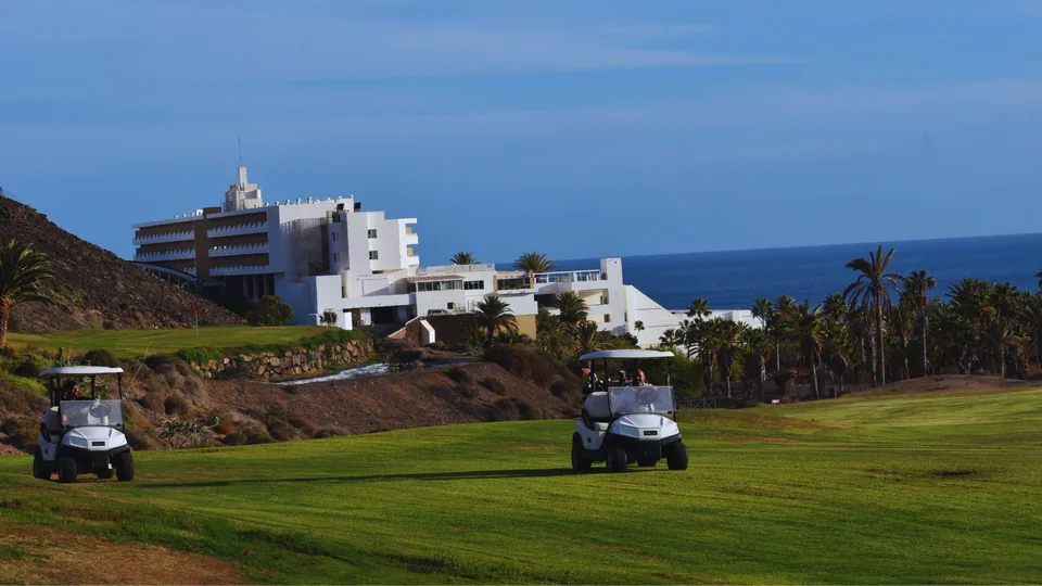 Golf carts with the hotel and sea behind